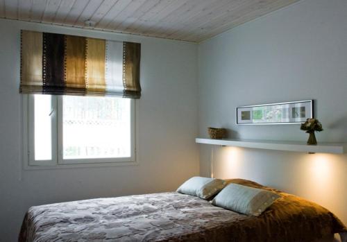 a bedroom with a bed and a window at Patalaiska Villas in Ruokolahti