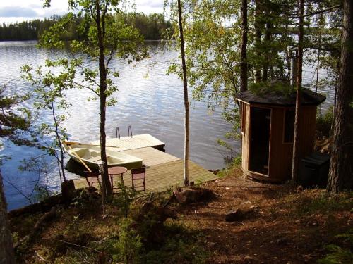 a small dock with a small boat on a lake at Patalaiska Villas in Ruokolahti