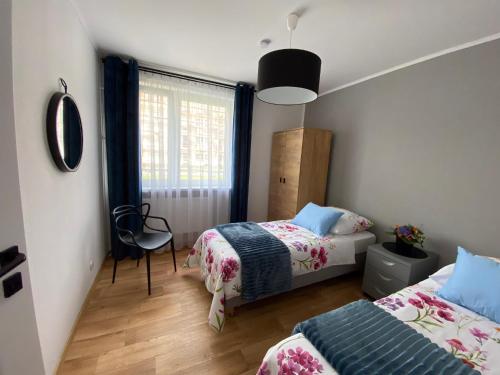 a bedroom with two beds and a window at OKO NA ZATOKĘ in Puck