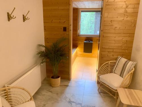 a hallway with chairs and a table and a plant at Penzion Pibernik in Bled