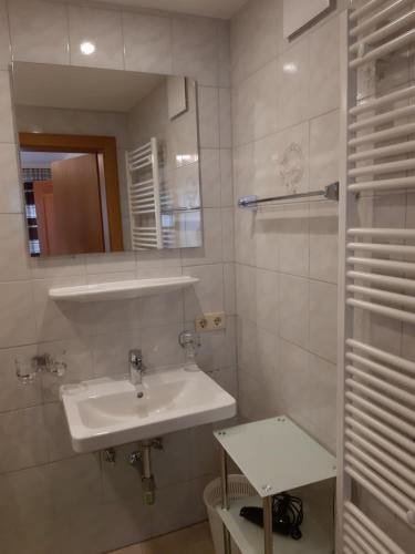 ein weißes Badezimmer mit einem Waschbecken und einem Spiegel in der Unterkunft Haus Arosa in Kappl