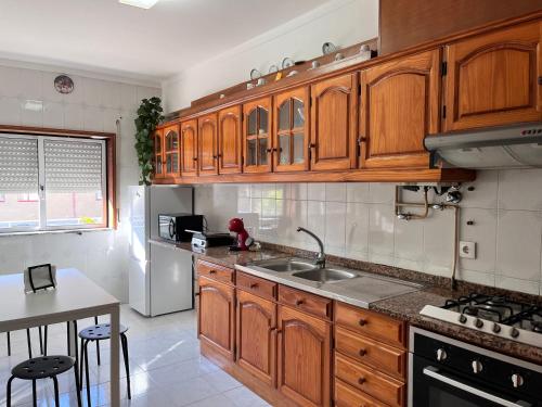 a kitchen with wooden cabinets and a sink at OFIR NATURE in Fão