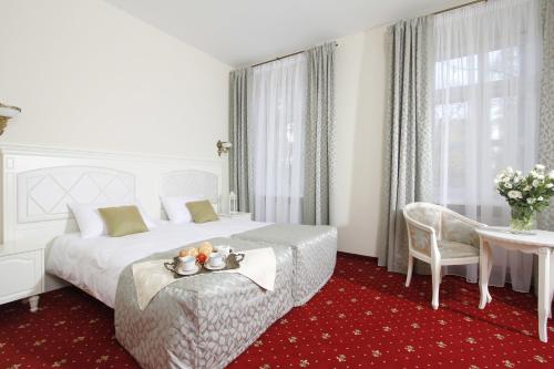 a hotel room with a large bed and a table at Lawendowy Dworek in Lublin