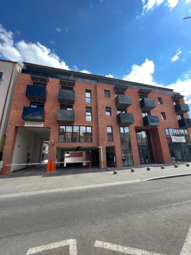 un edificio de ladrillo con balcones en el lateral de una calle en Opera Apartments en Cluj-Napoca