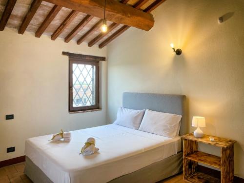 a bedroom with a bed with two ducks on it at Villaluce Wine Agriturismo in Castiglione del Lago