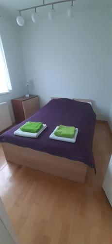 a bed with two green towels on top of it at Apartament Paderewski in Oleśnica