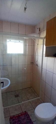 a bathroom with a toilet and a sink at Casa na Praia da Pinheira in Palhoça