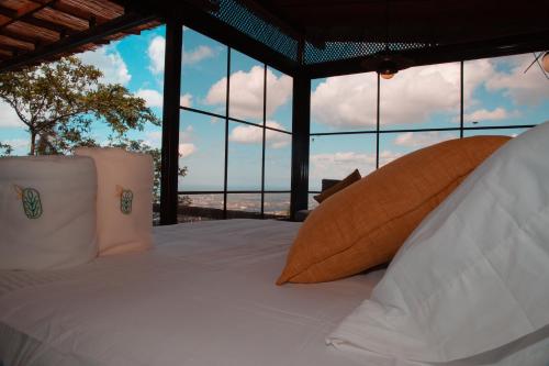 Waira Eco Lodge في فيلافيسينسيو: غرفة نوم مع سرير وإطلالة على المحيط