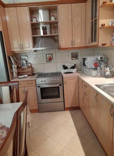 a kitchen with wooden cabinets and a stove top oven at Chrisa apartament in Metogjashta