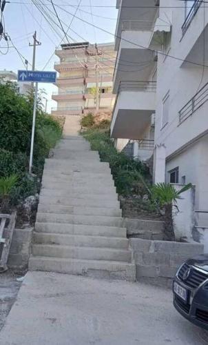 a staircase leading up to a building with a street sign at Chrisa apartament in Metogjashta