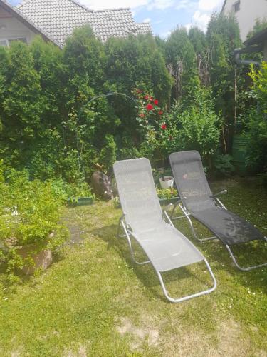 two chairs sitting in the grass in a yard at Fox Apartmanok in Hévíz