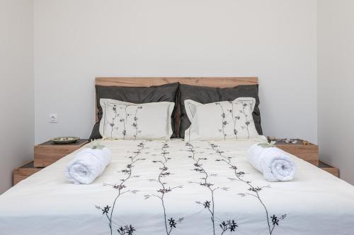 a bedroom with a large bed with white sheets and pillows at Blue Garden Samos Apartments in Samos