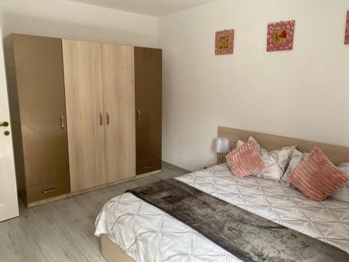1 dormitorio con 1 cama grande y algunos armarios en Rebeca Apartament, en Lugoj