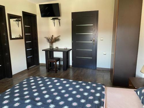 a bedroom with a bed and a table and a television at Privat FoRest in Liptovský Mikuláš