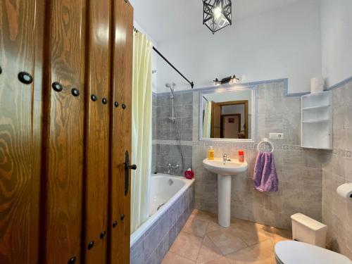 a bathroom with a tub and a sink and a toilet at FINCA EL ALMENDRO in Málaga
