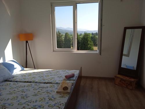 a bedroom with a bed with a mirror and a window at Linda apartment in Ulcinj