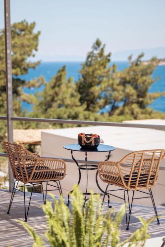 a table and two chairs sitting on a patio with the ocean at Blue Garden Samos Apartments in Samos