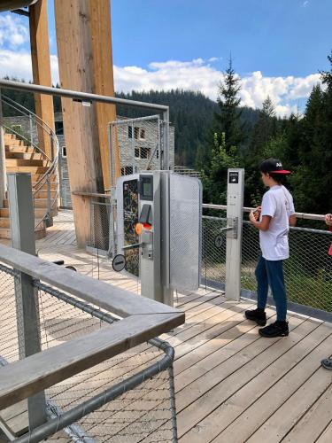 a young boy standing on a deck with a machine at Rancho Laaxdeluxe in Laax