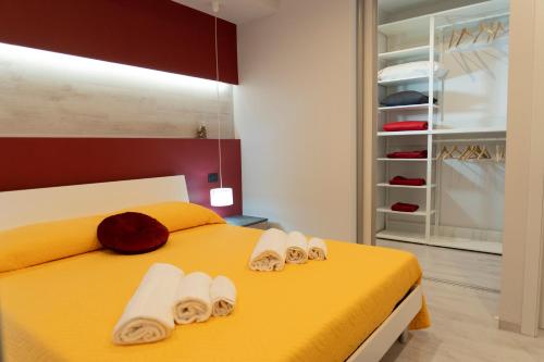 sypialnia z żółtym łóżkiem i ręcznikami w obiekcie HolidayDream Catania w Katanii