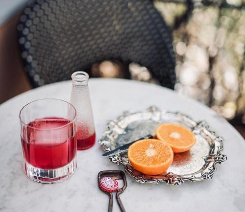 a table with a glass of red wine and orange slices at La Guta Studio Suite The Campari Suite in Jerusalem