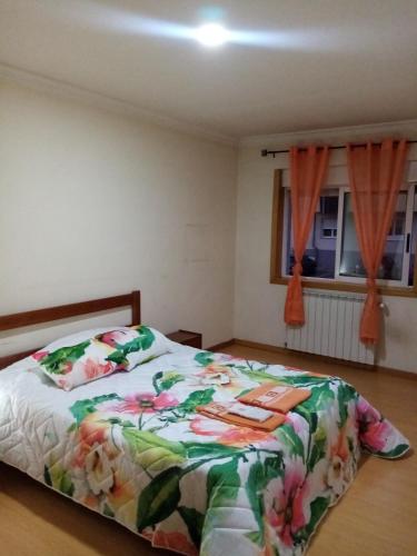 um quarto com uma cama com um edredão floral em Bragança Home For Working, Tourists, Erasmus Students, Digital Nomads em Brangança