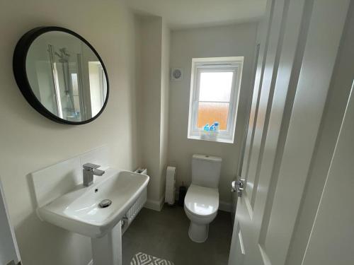 uma casa de banho com um lavatório, um WC e um espelho. em Stunning 3-Bed Risa House in Beeston Nottingham em Nottingham