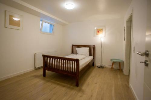 a small bedroom with a bed and a lamp at Business Apartment in Kaiserslautern