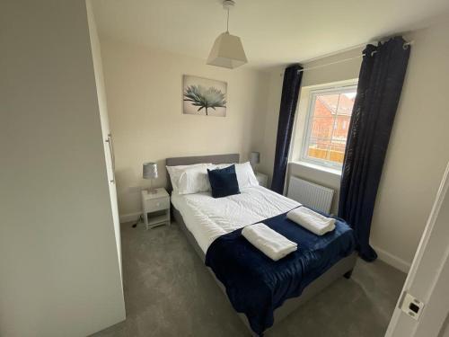 a bedroom with a bed with two pillows and a window at Stunning 3-Bed Risa House in Beeston Nottingham in Nottingham