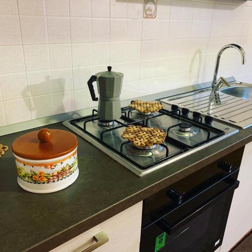 a stove top with a coffee pot and cookies on it at Vacanze in Puglia in Pezze di Greco