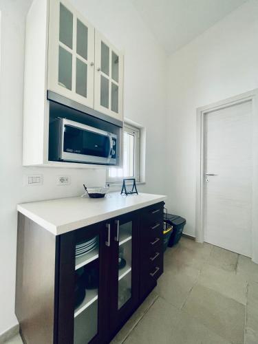 a kitchen with a counter and a microwave at A 2 passi dal mare Torre Faro LA PUNTA SeaHouse in Torre Faro