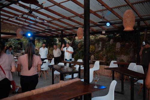 a group of people standing in a restaurant with tables and chairs at Waira Eco Lodge in Villavicencio