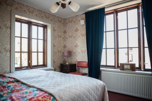 a bedroom with a bed and two windows at Matkustajakoti Ykspihlaja in Kokkola