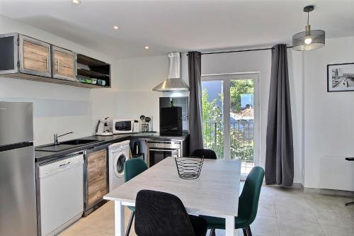 - une cuisine avec une table, une table et des chaises dans l'établissement Apt type 3 en Duplex sur EVIAN les Bains vue lac, à Évian-les-Bains