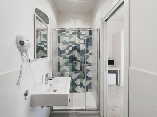 Minturnae Hotel في سكوري: حمام أبيض مع حوض ودش