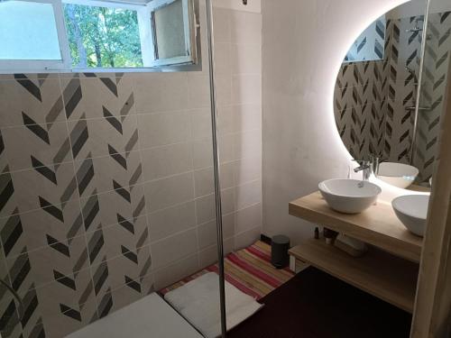 Baño con 2 lavabos y espejo en Maison au calme sur une propriété de 40 hectares en Bassillac