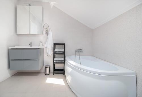 biała łazienka z wanną i umywalką w obiekcie Zola Guest House w mieście Oradea