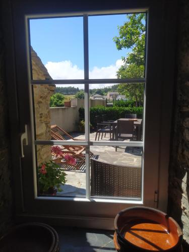 a window view of a patio with a table and chairs at Casa Rubal in Foz