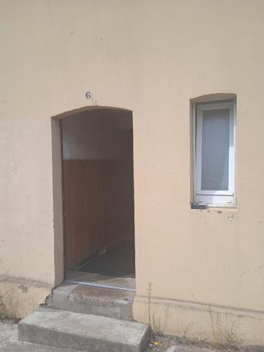 une porte sur le côté d'un bâtiment avec une fenêtre dans l'établissement Logement frontière du luxembourg, à Nilvange