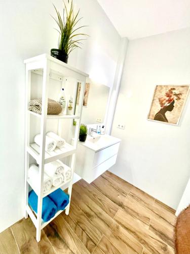a bathroom with a sink and a shelf with towels at Luxury Suite Sea Front V in Playa Honda