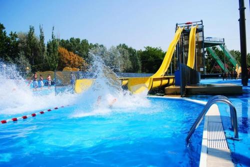 un enfant jouant dans une piscine avec toboggan dans l'établissement Luxueux appartement pied dans l'eau sur la plage d'Imi Ouaddar, à Agadir nʼ Aït Sa