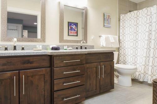 a bathroom with a sink and a toilet and a mirror at Fresh and Airy Condo in downtown Breck! in Breckenridge
