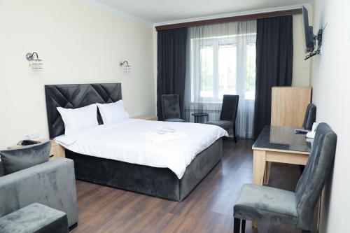a bedroom with a bed and a table and chairs at ARAGAST HOTEL & BREWERY пивоварня in Sevan