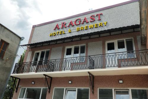 an apartment building with a sign for aarcass hotel and brewery at Aragast Hotel & Brewery in Sevan