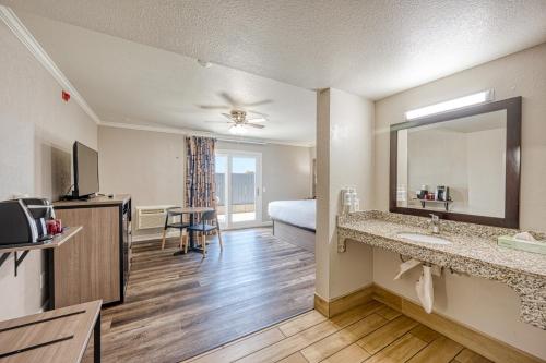 a hotel room with a bed and a bathroom at Harbor House Inn in Morro Bay