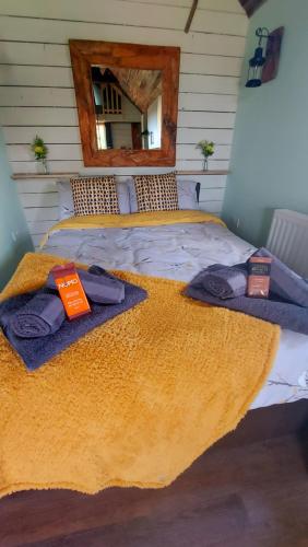 a bedroom with a bed with towels and a mirror at Lake View Lodges in Long Melford