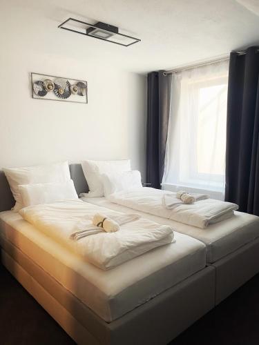 two white beds in a room with a window at Cozy Apartment Bernburg 3 in Roschwitz