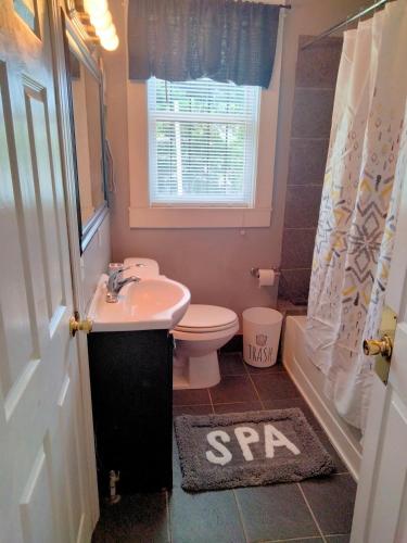 a bathroom with a sink and a toilet and a window at Birmingham's Spacious Uptown Family Retreat in Birmingham