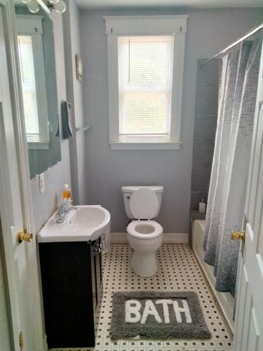 a bathroom with a toilet and a sink and a bath rug at Birmingham's Spacious Uptown Family Retreat in Birmingham
