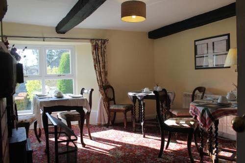 a dining room with two tables and chairs and a window at Belle Green Bed and Breakfast in Sawrey