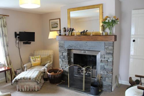 a living room with a fireplace with a mirror at Belle Green Bed and Breakfast in Sawrey